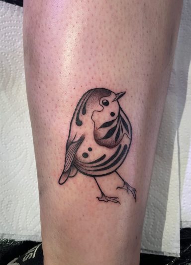 Tattoo of a stylised bird standing on a leg.
